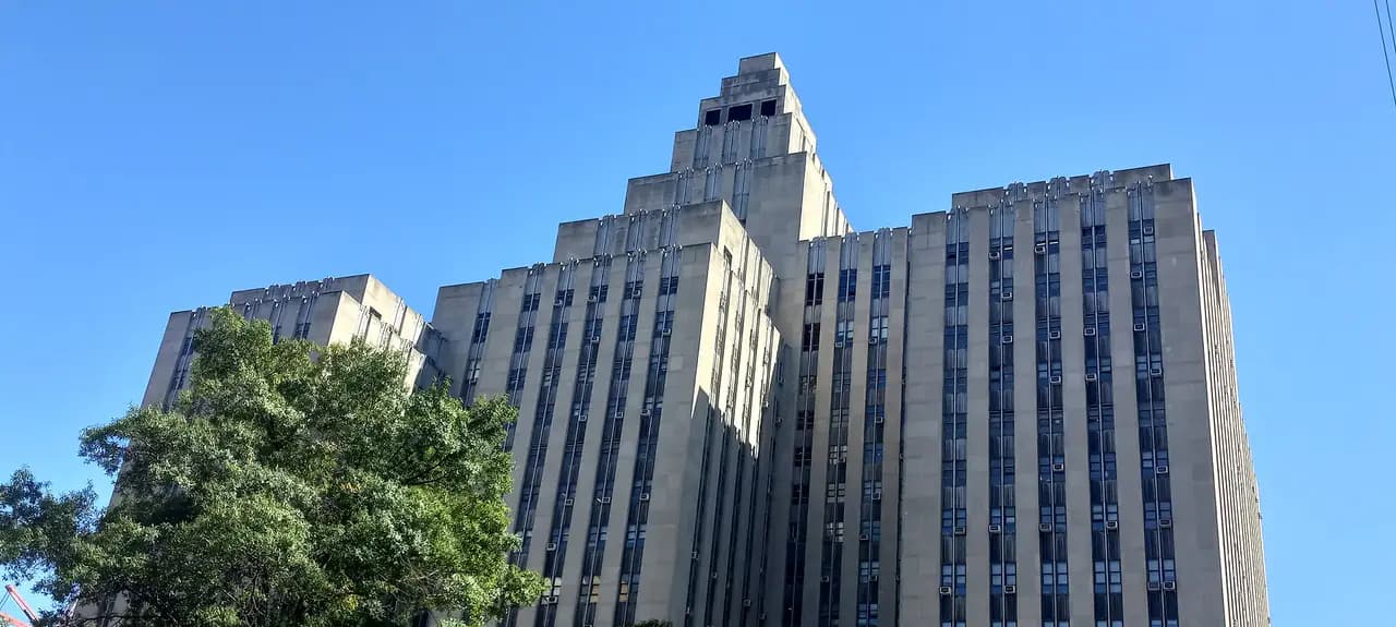 The tall stone facade of the Manhattan Criminal Courts Building at 100 Centre Street