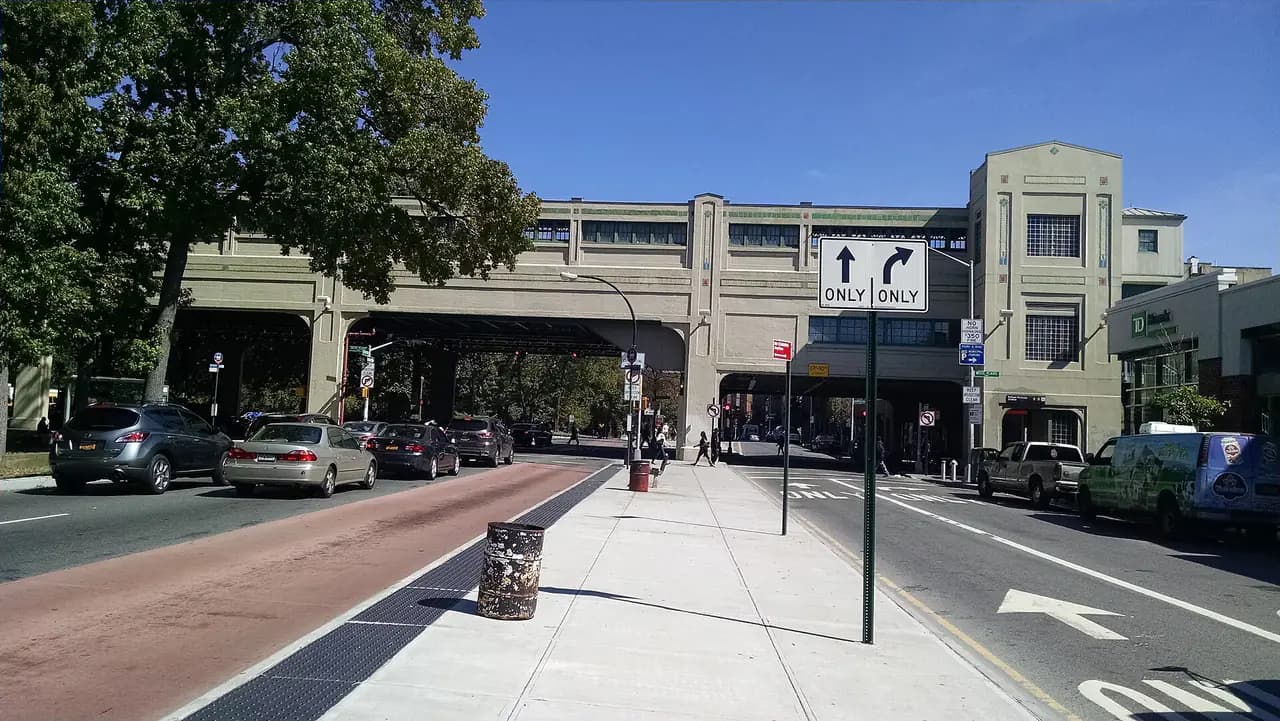 Pelham Parkway at White Plains Road in the Bronx, with apartment buildings and the elevated subway line
