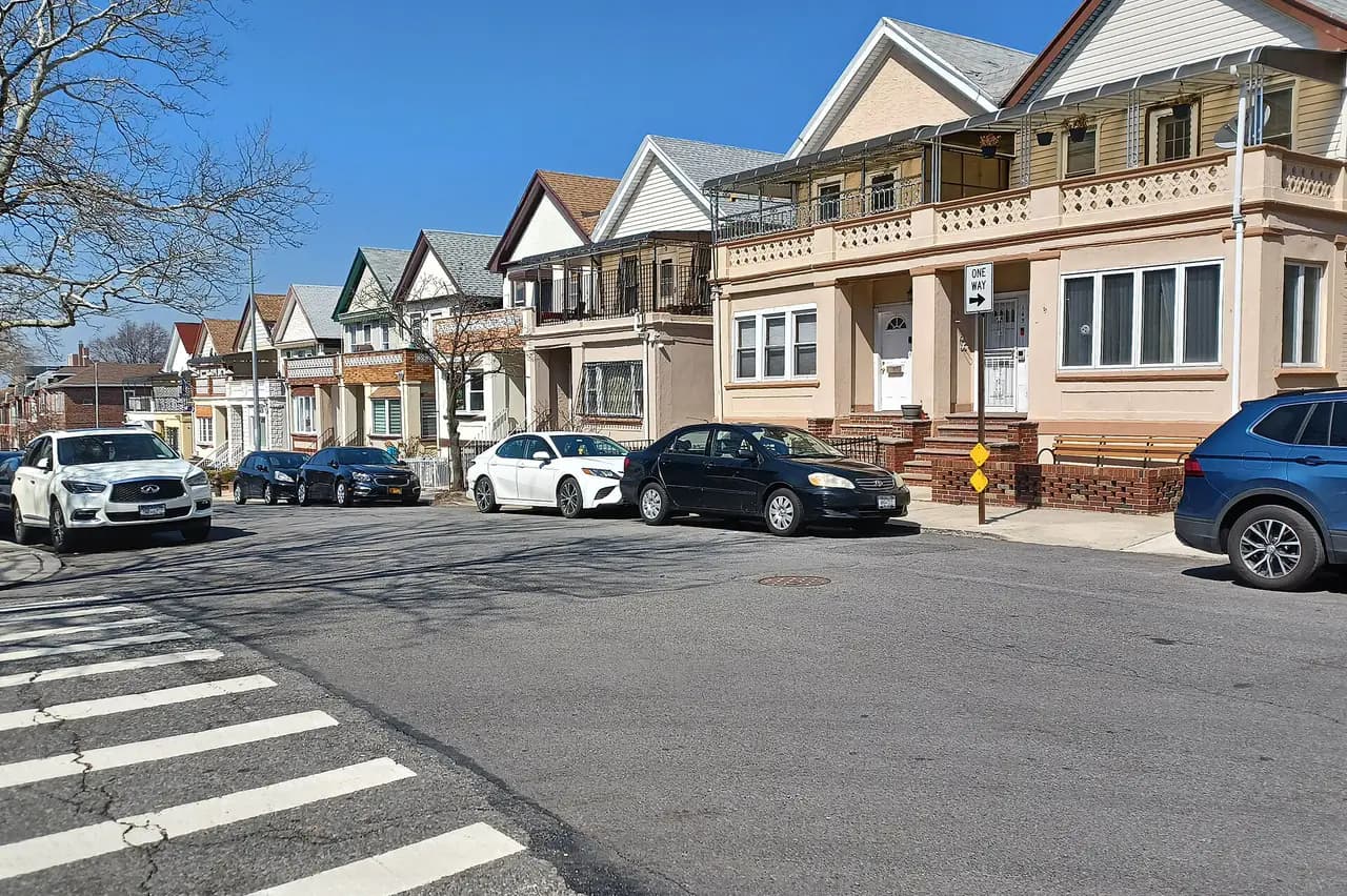 Row of two-story homes with gabled roofs and parked cars on 70th Street in Bay Ridge, Brooklyn