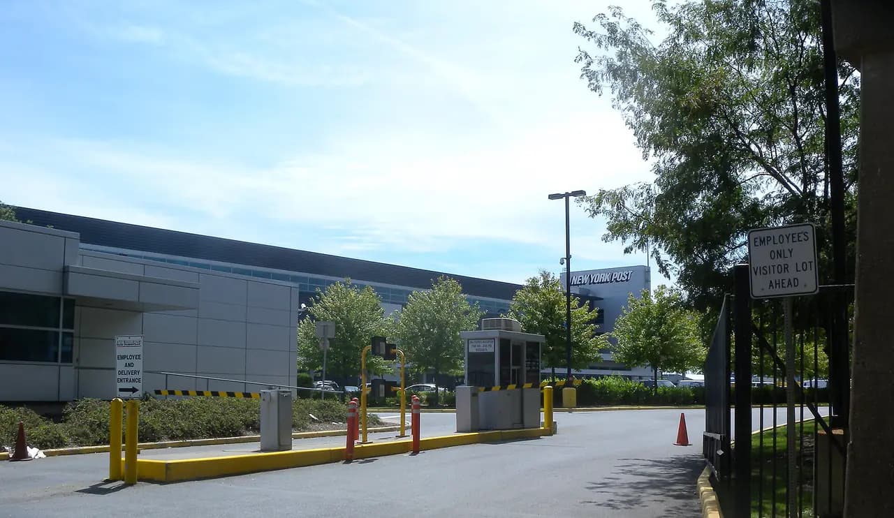 A truck gate and driveway leading into a long, low industrial building on East 133rd Street in the Bronx