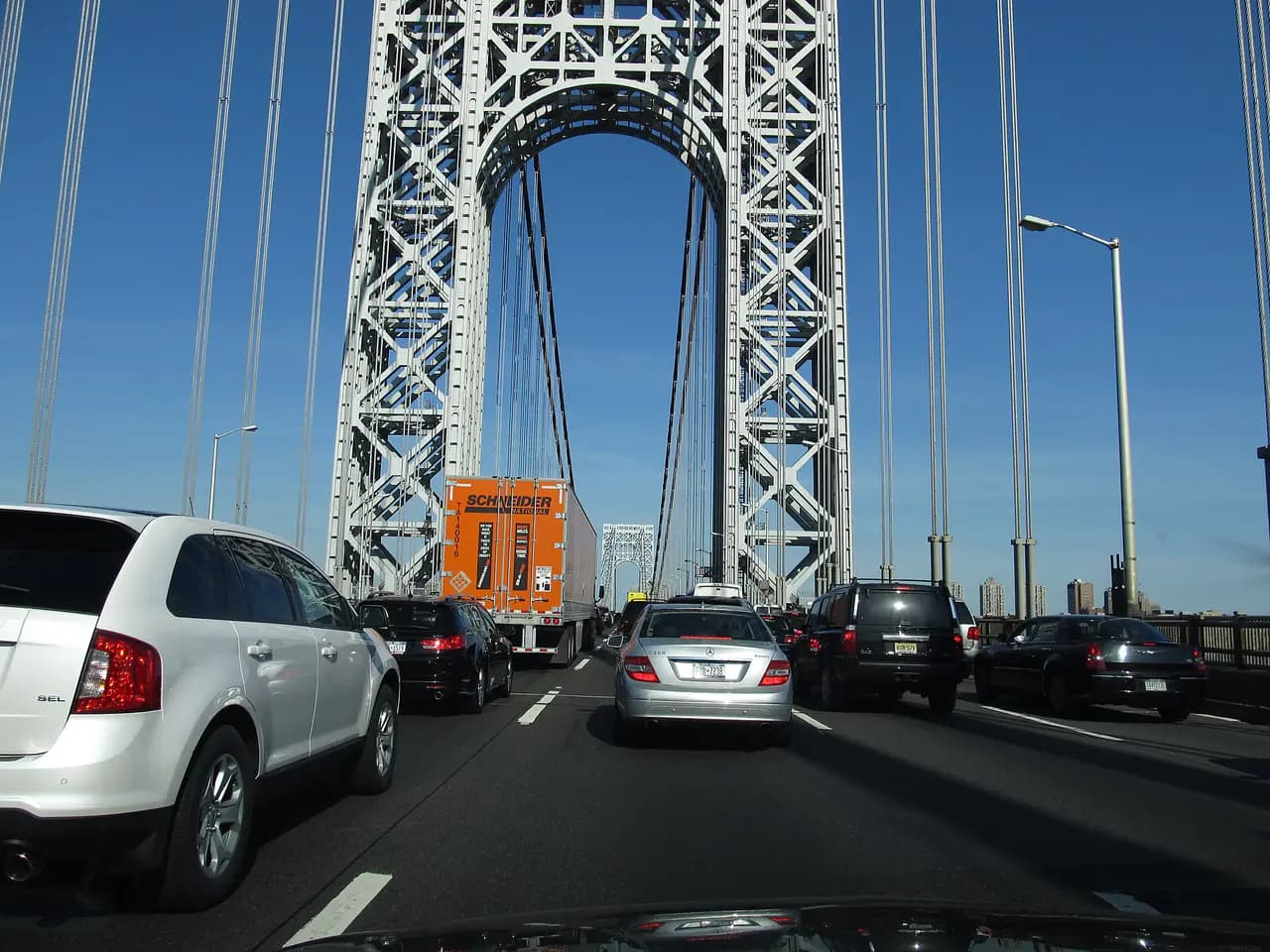 Cars on the upper level roadway of the George Washington Bridge, with one of the bridge's steel towers ahead