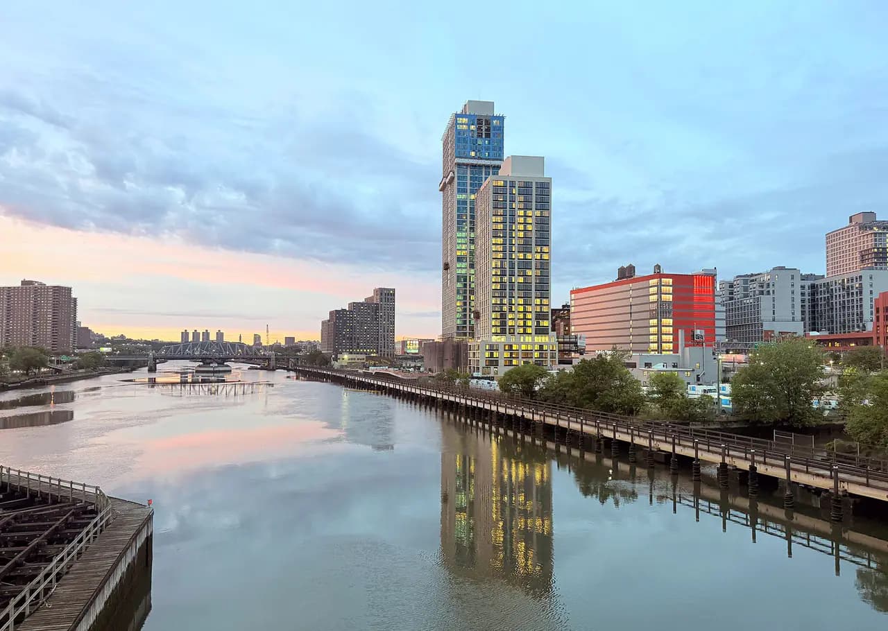 The One River Park towers at 355 Exterior Street rise over the Harlem River in the South Bronx at dusk