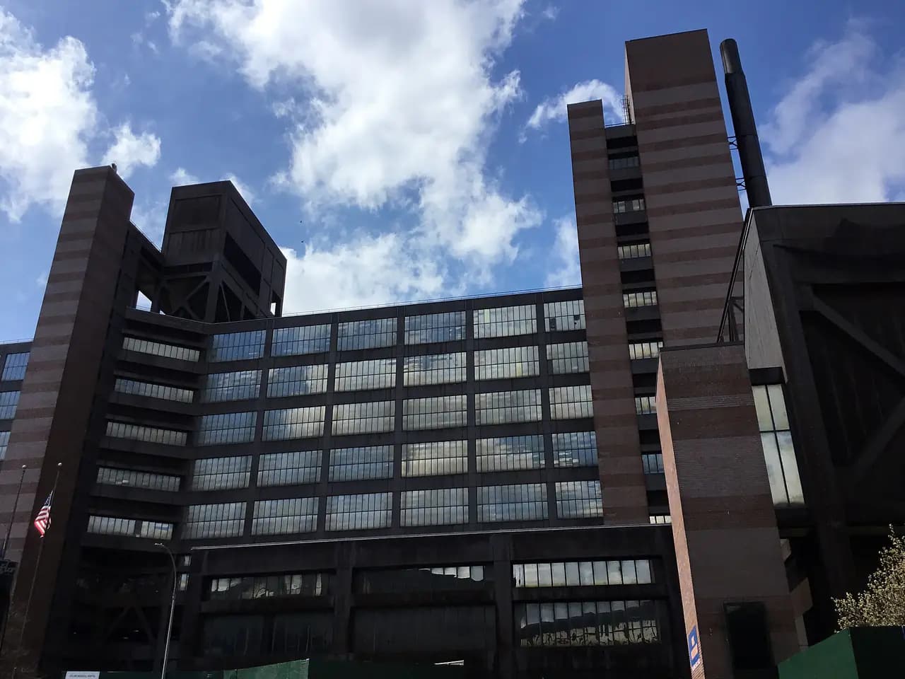 The large brown brick and glass Woodhull Hospital and Mental Health Center building in Bushwick, Brooklyn, seen from the street