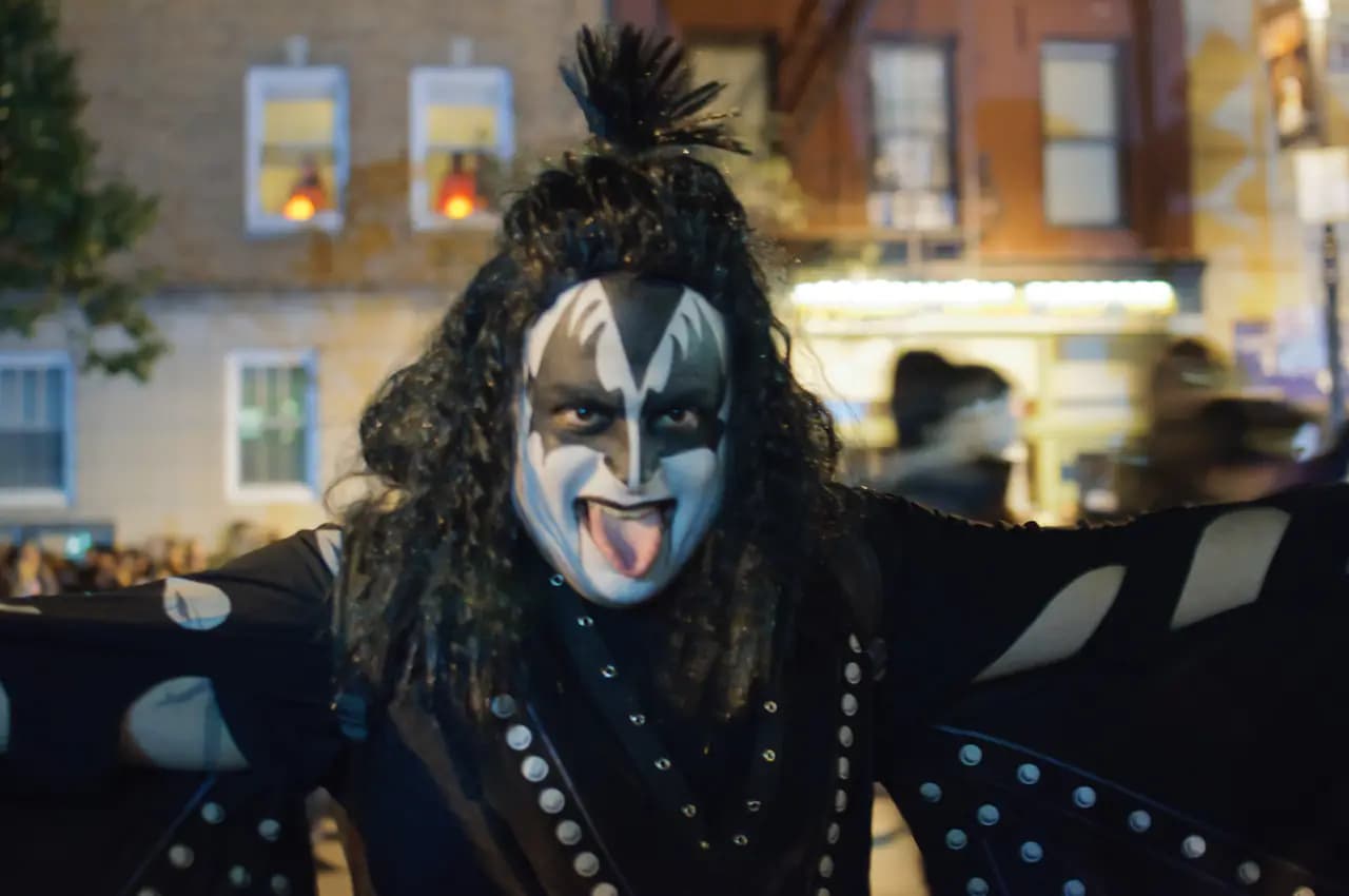 A marcher in black-and-white face paint and a winged costume at the Village Halloween Parade on Sixth Avenue