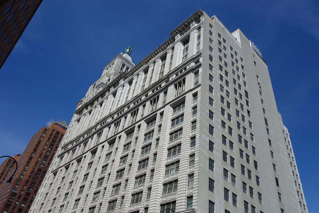 Looking up at the white facade and clock tower of the Con Edison headquarters building at 14th Street and Irving Place in Manhattan