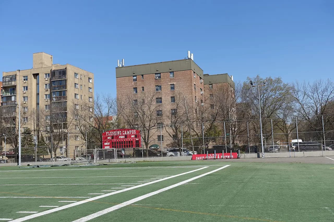 A turf athletic field at Leavitt Park in Flushing, with apartment buildings behind it