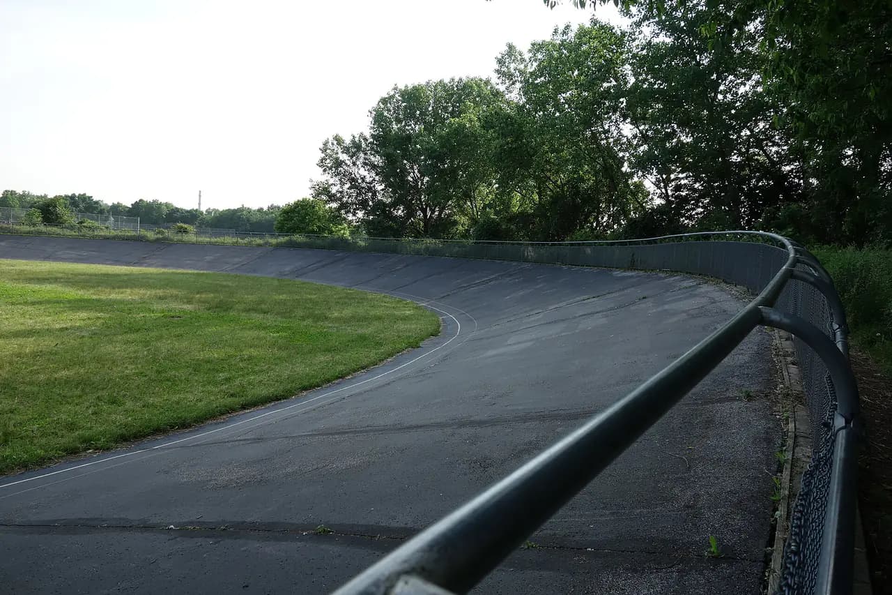 The banked oval track of the Kissena Velodrome surrounded by trees in Kissena Park, Flushing