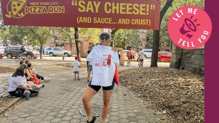 Woman standing in front of banner that reads “Say Cheese (And Sauce…And Crust)”