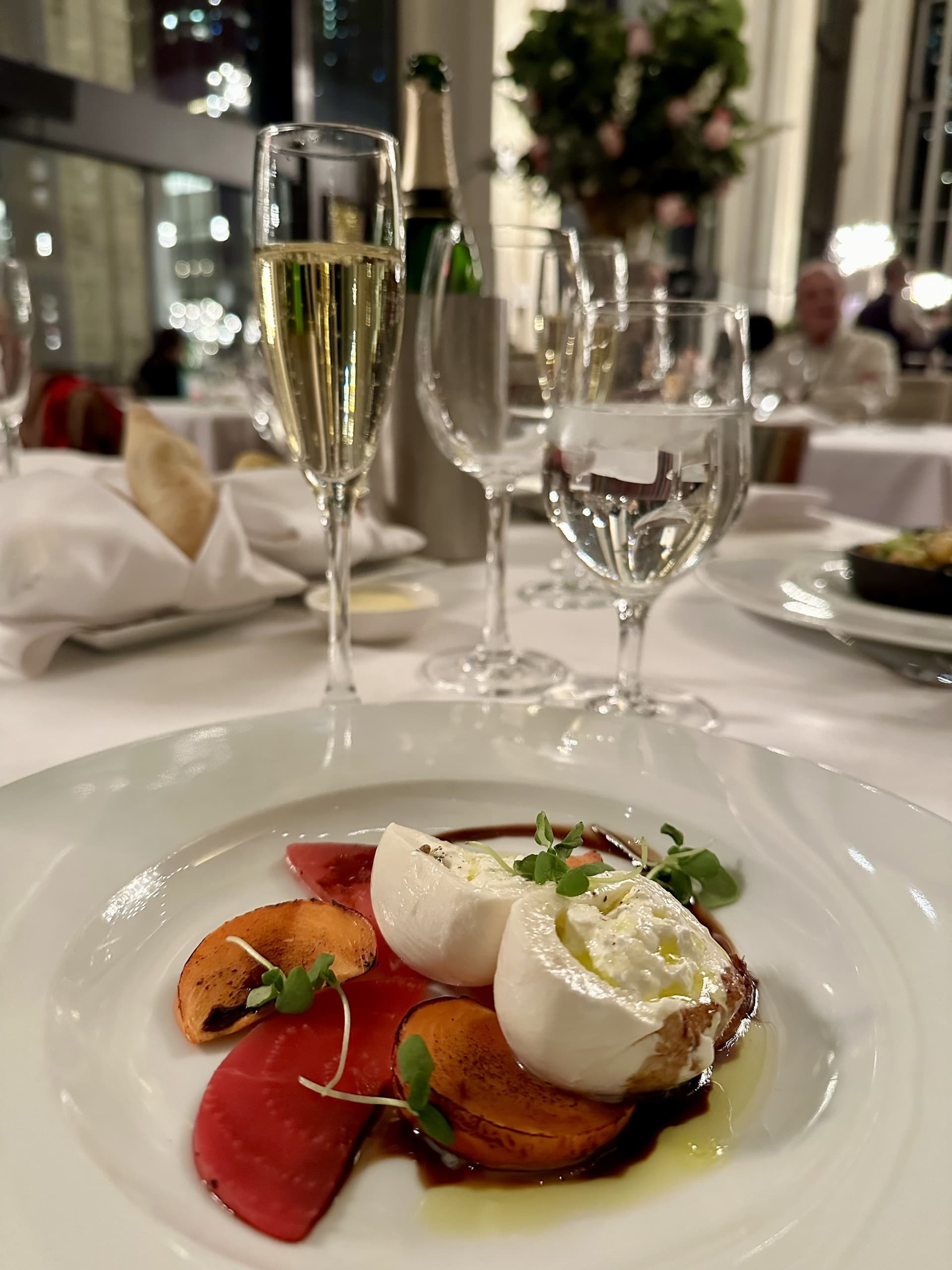 A dish with burrata and wine.
